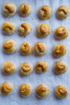 small pastries are lined up on a piece of parchment paper, ready to be baked