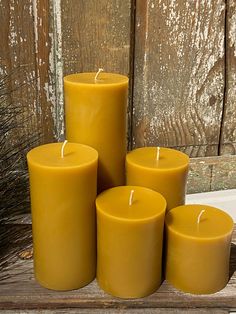 five yellow candles sitting on top of a wooden table