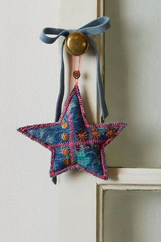 a blue star hanging from the side of a white door with a bell on it