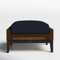 the foot stool is made out of wicker and blue cushioned material, with dark wood legs