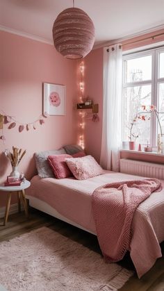 a bedroom with pink walls and white carpeted flooring is decorated in pastel tones