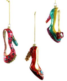 three christmas ornaments hanging from chains on a white background, each decorated with different colored shoes