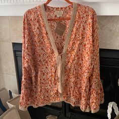 This Is A Fun Boho Top With Front Tie Closure, Full Sleeves With Ruffles At Bottom. Lace Detailing And Pretty Floral Print! This Looks Great With A Tank Top Underneath Paired With Jeans Or A Skirt! Peach Blouse For Beach, Spring Season, Peach Blouse For Beach In Spring, Peach Blouse For Spring Beach Occasions, Orange V-neck Blouse For Vacation, Orange Cotton Blouse For Day Out, Orange Summer Blouse For Vacation, Spring Cotton Orange Blouse, Spring Orange Cotton Blouse, Orange Cotton Blouse With Floral Print