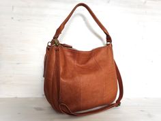 This tan brown hobo bag is handmade from beautiful super soft natural leather.  It is of a large size (not oversized) and will fit all your daily necessities.  The leather is soft to touch, and the bag feels very comfortable on the shoulder. It has two straps - a shorter shoulder strap; and a longer adjustable and detachable shoulder / cross body strap. You can wear this bag in many different ways! DIMENSIONS + width 13.8" / 35 cm + height 12.6" / 32 cm + depth 4.7" / 12 cm + top shoulder strap Light Brown Crossbody Hobo Bag For Everyday, Everyday Light Brown Crossbody Hobo Bag, Everyday Light Brown Satchel Hobo Bag, Cognac Hobo Bag For Daily Use, Brown Hobo Bag For Everyday, Brown Hobo Bag With Handles For Daily Use, Brown Soft Leather Hobo Bag For On-the-go, Daily Use Cognac Hobo Bag With Handles, Daily Use Cognac Hobo Bag