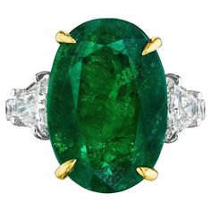 • Platinum & 18KT Two Tone • Size 6.5 • 9.68 Carats • Number of Oval Emeralds: 1 • Carat Weight: 8.54ctw • 16.80 x 11.70mm • Number of Brilliant Trapezoid Diamonds: 2 • Carat Weight: 0.64ctw • Number of Round Diamonds: 10 • Carat Weight: 0.50ctw • This ring showcases an 8.54ct oval cut green emerald center stone. The emerald is flanked by 2 brilliant cut trapezoid diamond side stones, and round diamonds down the band. The green emerald is secured by 18KT yellow gold prongs, highlighting its colo Round Diamond Ring, Cute Nike Shoes, Cute Nikes, Oval Rings, Round Rings, Green Emerald, 2 Carat, 1 Carat, Wedding Bells