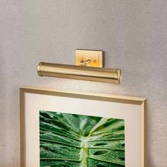 a framed photograph hanging on the wall next to a toilet paper dispenser