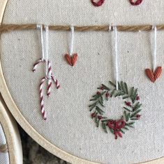 a close up of a piece of embroidery on a table with ornaments hanging from it