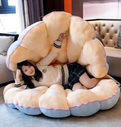 a woman laying on top of a giant stuffed animal chair