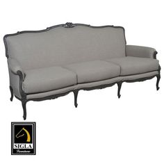 an old fashioned couch with black trim and gold detailing on the arm, sitting against a white background