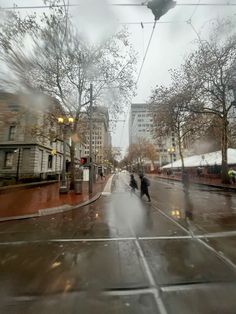 two people walking down the street on a rainy day