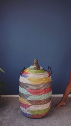 a person standing next to a colorful basket