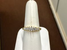 "The item is a 18 k yellow gold marquise diamond ring. The ring consists of nine marquise shaped diamonds that graduate in size from 5 x 2.5 millimeters down to 2.5 x 1.5 millimeter. The total carat weight of the diamonds is 0.65 carats. The diamonds have a \"H\" color and an \"SI 1\" clarity grading. Each diamond is held in with two prongs. The ring is a finger size 8 and I can size it for you at no charge. The ring weighs 4.8 grams. I will provide a ring box. I can also provide a free written Formal Yellow Gold Marquise Diamond Ring, Classic Marquise Diamond Ring With Vs Clarity, Formal Marquise Diamond White Diamond Ring, Marquise Yellow Gold Diamond Ring With Accents, Marquise Diamond Ring With Vs Clarity, Marquise Cubic Zirconia Diamond Ring With Single Diamond, Marquise Cubic Zirconia Ring With Single Diamond, Classic Marquise Yellow Gold Cluster Ring, Classic Marquise Cluster Ring With Single Cut Diamonds