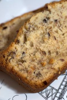 two slices of banana bread sitting on top of a white and blue plate with black writing