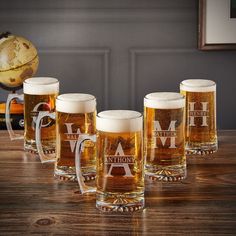 four beer mugs with the letters i, v, and l on them sitting on a table