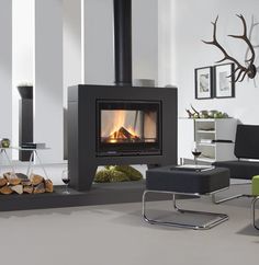 a living room filled with furniture and a fire place next to a wall mounted fireplace