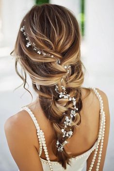 the back of a woman's head with pearls in her hair