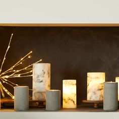 candles are lined up in front of a blackboard with gold sparklers on it