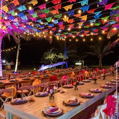 the tables are set up for an event with colorful lights and decorations hanging from the ceiling