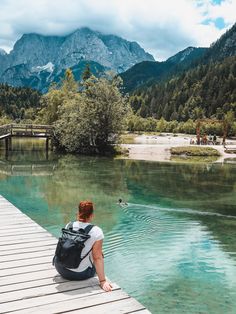 a person sitting on a dock looking at the water