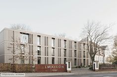 the building has many windows and is next to a street with trees on both sides