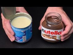 a person holding a jar of nutella next to a container of peanut butter on a black surface