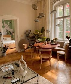 a living room filled with furniture next to a window covered in plants and potted plants