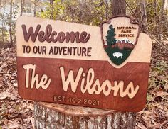 the welcome sign to the wildlife park is posted on a tree stump in the woods