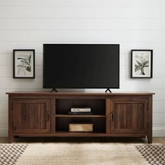 a flat screen tv sitting on top of a wooden entertainment center in a living room