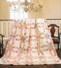 a quilted blanket on top of a table next to a chandelier