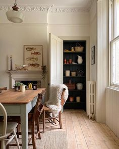 a dining room table with chairs and bookshelf in the background