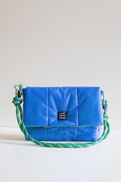 The outer surface of the Blue Candy bag is quilted with colored vinyl material and fiber. The inside of the Blue Candy Bag is light green lined. The strap of the bag is made of rope material. The strap is adjustable. It can be used as a shoulder bag and a crossbody bag. The strap is interchangeable. Product Dimensions 11*7*2 Square Nylon Shoulder Bag With Adjustable Strap, Blue Nylon Shoulder Bag With Detachable Strap, Trendy Blue Outdoor Bags, Green Quilted Bag For Travel, Trendy Blue Shoulder Bag For Outdoor, Functional Quilted Rectangular Shoulder Bag, Blue Nylon Shoulder Bag For Outdoor, Rectangular Nylon Bag With Adjustable Handle, Blue Quilted Crossbody Bag