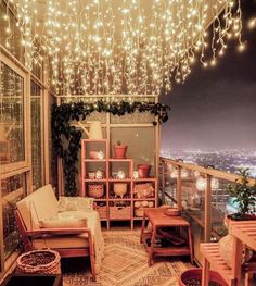 a balcony with lights hanging from it's ceiling and furniture on the other side