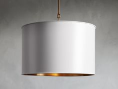 a white lamp hanging from a ceiling with a gold ring around the neck and bottom