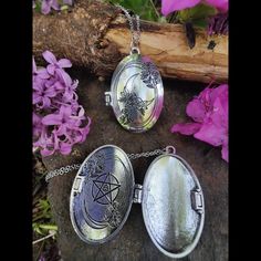 three silver lockes sitting on top of a rock next to purple flowers and a tree branch