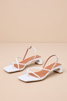 The Intentionally Blank Fifi Ice White Leather Strappy Slingback Low Heel Sandals pair to perfection with warm sunny days! Smooth genuine leather shapes these effortlessly chic sandals that feature a square footbed and a thong-style upper that flows into an asymmetrical strappy vamp. A trendy slingback strap sprouts from the sides and secures at the outstep with a shiny silver buckle. A low, slender block heel completes the coveted look! Available in Euro sizes only. 1. 25" wrapped block heel. C Elegant High Heel Slingback Sandals For Vacation, Chic Summer Slingback Sandals With Heel Loop, Elegant Slingback Sandals With Block Heel For Vacation, Chic Slingback Sandals With Strap For Summer, Chic Summer Slingback Pumps With Block Heel, Chic Slingback Sandals For Summer, Chic Summer Slingback Sandals With Strap, Elegant Open Heel Slingback Sandals For Vacation, Elegant Slingback Sandals For Spring Vacation