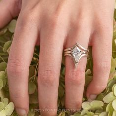 a woman's hand with a wedding ring on top of her finger, surrounded by flowers