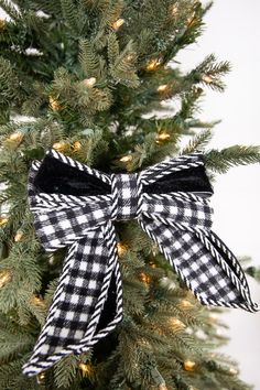 a black and white bow on top of a christmas tree