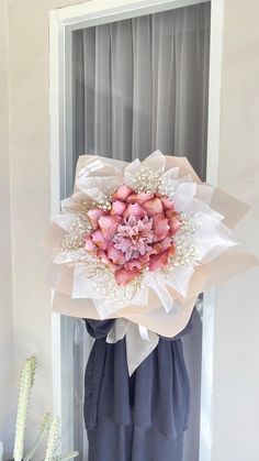 a bouquet of flowers sitting on top of a window sill next to a cactus