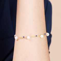 A delicate cultured freshwater pearl fine chain bracelet with a modern twist.    This elegant bracelet combines almost round cultured freshwater pearls with lapis lazuli gemstones to create a stunning piece to be worn day or night.  The perfect gift for a September birthday baby as lapis lazuli is their birthstone.  Non-tarnish gold style chain bracelet with almost round cultured freshwater pearls & lapis lazuli gemstones on a gold plated sterling silver lobster clasp - approx. 7. 5" with chain.  Please note pearls are organic and may vary in size and may differ in number from the image. Pearls are quite soft and need special care after you wear them. Always store them in a separate jewellery pouch away from other jewellery and it is best to keep them in something soft.  From time to time, Elegant Wire Wrapped Pearl Bracelet, Elegant Blue Pearl Bracelet With Charm, Elegant Blue Beaded Bracelets With Pearl Charm, Elegant Blue Beaded Bracelet With Pearl Charm, Elegant Blue Chain Bracelet As Gift, Elegant Blue Chain Bracelet For Gift, Elegant Blue Bracelets With Delicate Chain, Elegant Blue Bracelet With Delicate Chain, Elegant Blue Round Pearl Bracelet