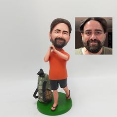 a bobble head with a man holding a backpack next to it's face