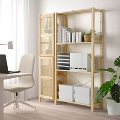 a computer desk with a laptop on top of it next to a book shelf filled with books