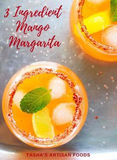 two glasses filled with orange margaritas on top of a metal tray