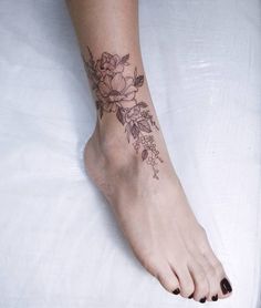 a woman's foot with a flower tattoo on her left side and the bottom part of her leg