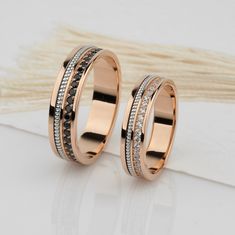 two tone gold wedding rings with black and white diamonds on each side, set in 18k rose gold