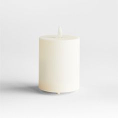 a white candle with a single lit candle in the middle on a plain surface,