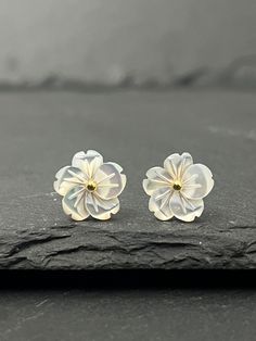 Romantic earrings in white mother-of-pearl and 18K gold-colored stainless steel. These stud earrings are shaped like a pretty white flower. They will be ideal for a wedding, for bridesmaids, or to give a gift. ---------- MATERIAL AND DIMENSION ----------- ◾ White natural mother-of-pearl with its reflections. ◾ 18K gold-colored stainless steel. Stainless steel is non-corrosive. It does not oxidize like silver, it will resist over time and retain its shine. Robust, they will resist water. They are Pearl White Flower Earrings As Gift, White Flower Shaped Pearl Earrings For Gift, Anniversary Pearl White Flower Earrings For Pierced Ears, Delicate White Pearl Pierced Earrings, Elegant White Flower Earrings Gift, White Pearl Earrings With 3d Flowers For Gift, White Pearl Earrings With 3d Flowers As Gift, White Flower Pearl Earrings For Anniversary, White Earrings With 3d Flowers For Anniversary