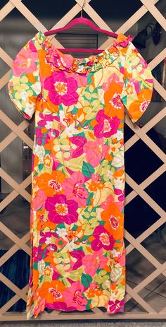 Fabulous handmade  neon floral, maxi dress with ruffle accent neckline 1970s handcrafted tuilp short sleeve long dress is perfect for any Hawaiian themed event or outing.  The color is vibrant with flowers in orange, lime green, lemon yellow and bright pink. Dress closes with a zipper back. We are guessing this is a cotton poly blend. There is no fabric tag due to it being handmade. There is an extra 3 inches that could be let out to make the dress longer.  Measurements:  as a handcrafted garment there is no size tag so please pay particular attention to the measurements below.   Shoulders:  17" (34" doubled) Bust:  18" (36" doubled) Waist: 18" (36" doubled) Hips: 18" (36" doubled) Top front to hem: 50" Back top to hem: 46" Side slits on either side of 19" Condition:  vintage excellent; no Retro Multicolor Maxi Dress For Spring, Vibrant Short Sleeve Maxi Dress With Floral Print, Retro Spring Maxi Dress With Vibrant Print, Spring Retro Print Maxi Dress, Spring Maxi Dress With Retro Print, Spring Retro Print Dresses With Short Sleeves, Spring Retro Print Short Sleeve Dresses, Retro Print Short Sleeve Dresses For Spring, Vibrant Short Sleeve Maxi Dress For Spring