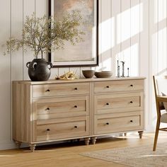 a wooden dresser with two vases on top of it