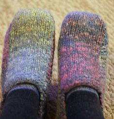 two pairs of colorful socks sitting on top of a carpet