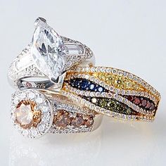 three different colored diamond rings on top of each other in gold, silver and white